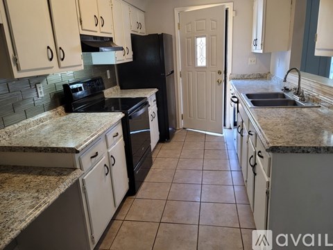 A kitchen with granite countertops and black appliances.