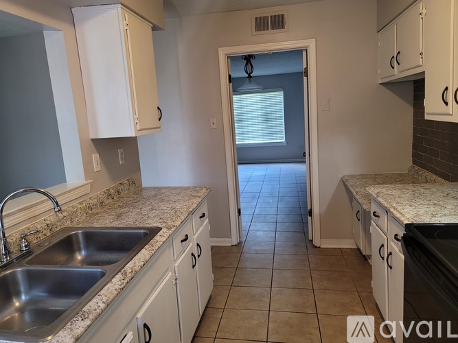 A kitchen with granite countertops and white cabinets.