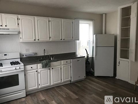 A kitchen with white appliances and cabinets.