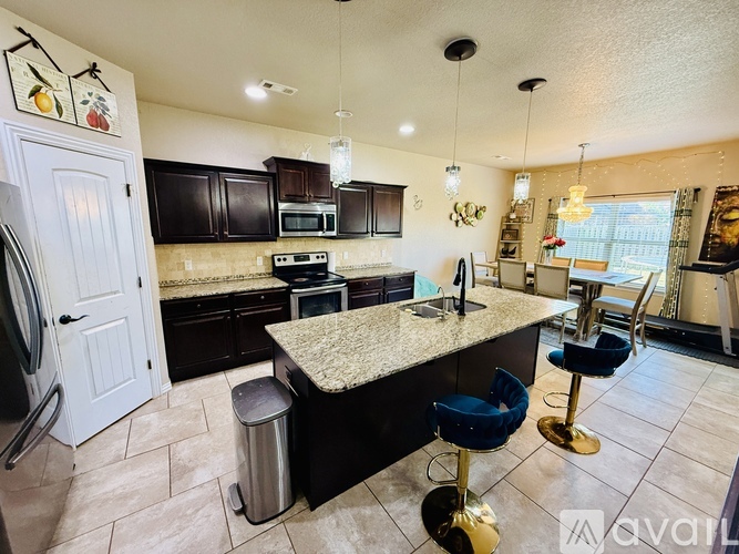 A kitchen with black cabinets and a granite countertop.
