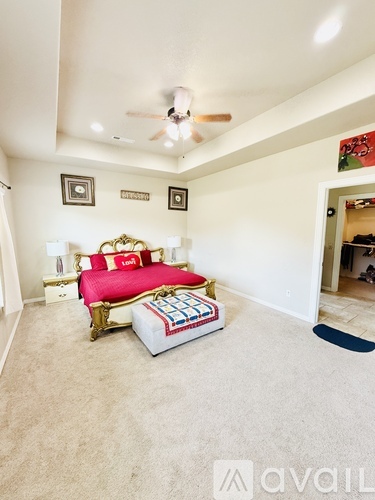 A bedroom with a bed and a ceiling fan.