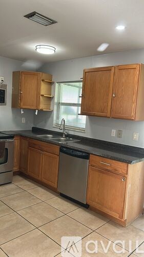 A kitchen with wooden cabinets and a black countertop.