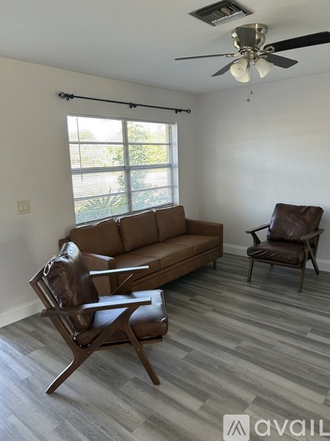 A room with a ceiling fan and tile flooring.