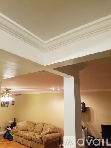 A living room with a couch and a fan on the ceiling.