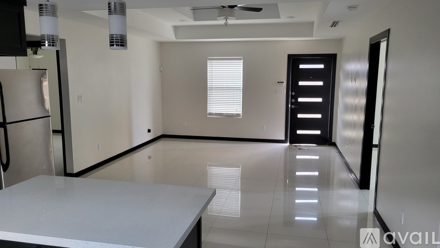 A spacious kitchen with a white countertop and a ceiling fan.