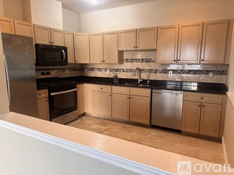 A kitchen with wooden cabinets and a black countertop.