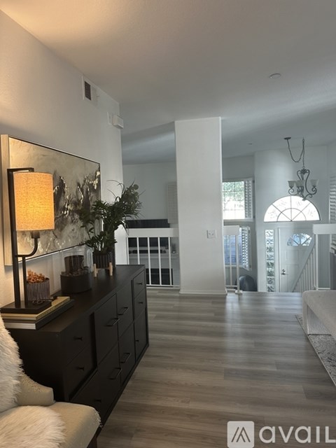A modern living room with a white couch and a wooden floor.