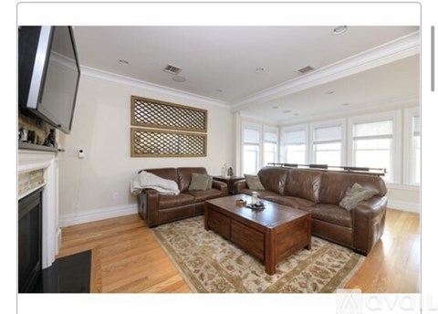 A living room with a brown couch and a fireplace.