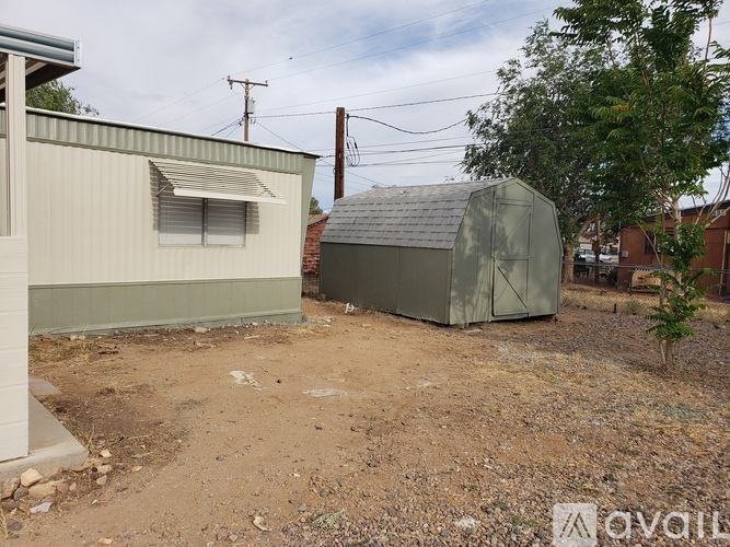 A dirt area with a building and a shed.