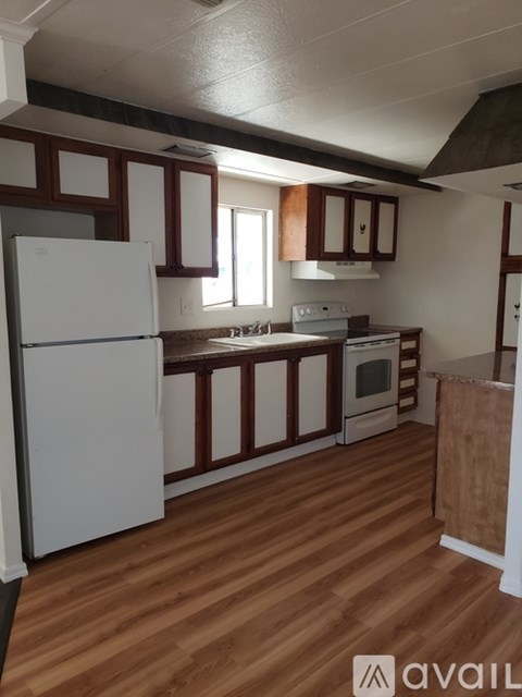 A kitchen with wooden floors and white appliances.