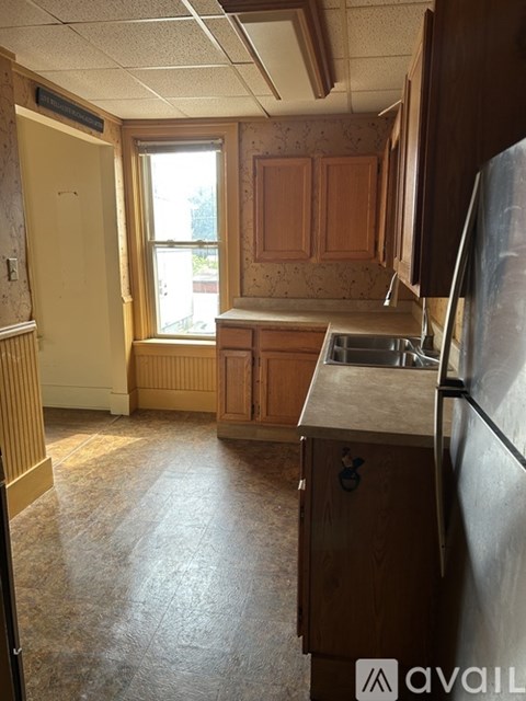 A kitchen with wooden cabinets and a window.
