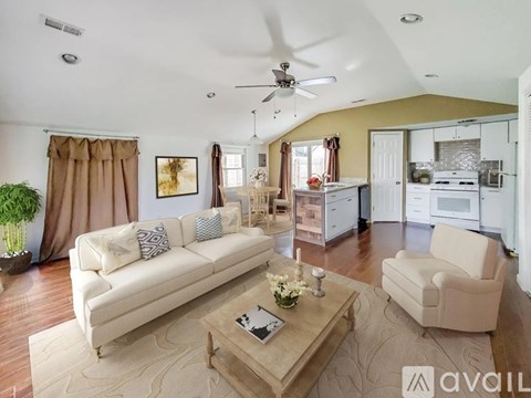 A living room with a white couch and a coffee table in the middle.