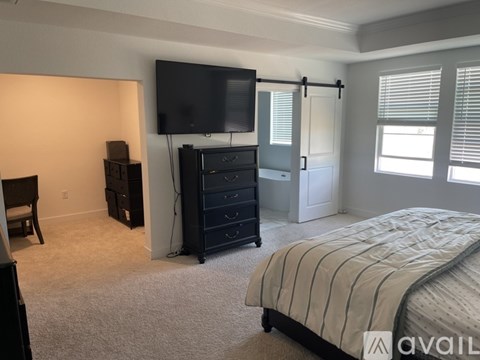 A bedroom with a bed, dresser, and television.