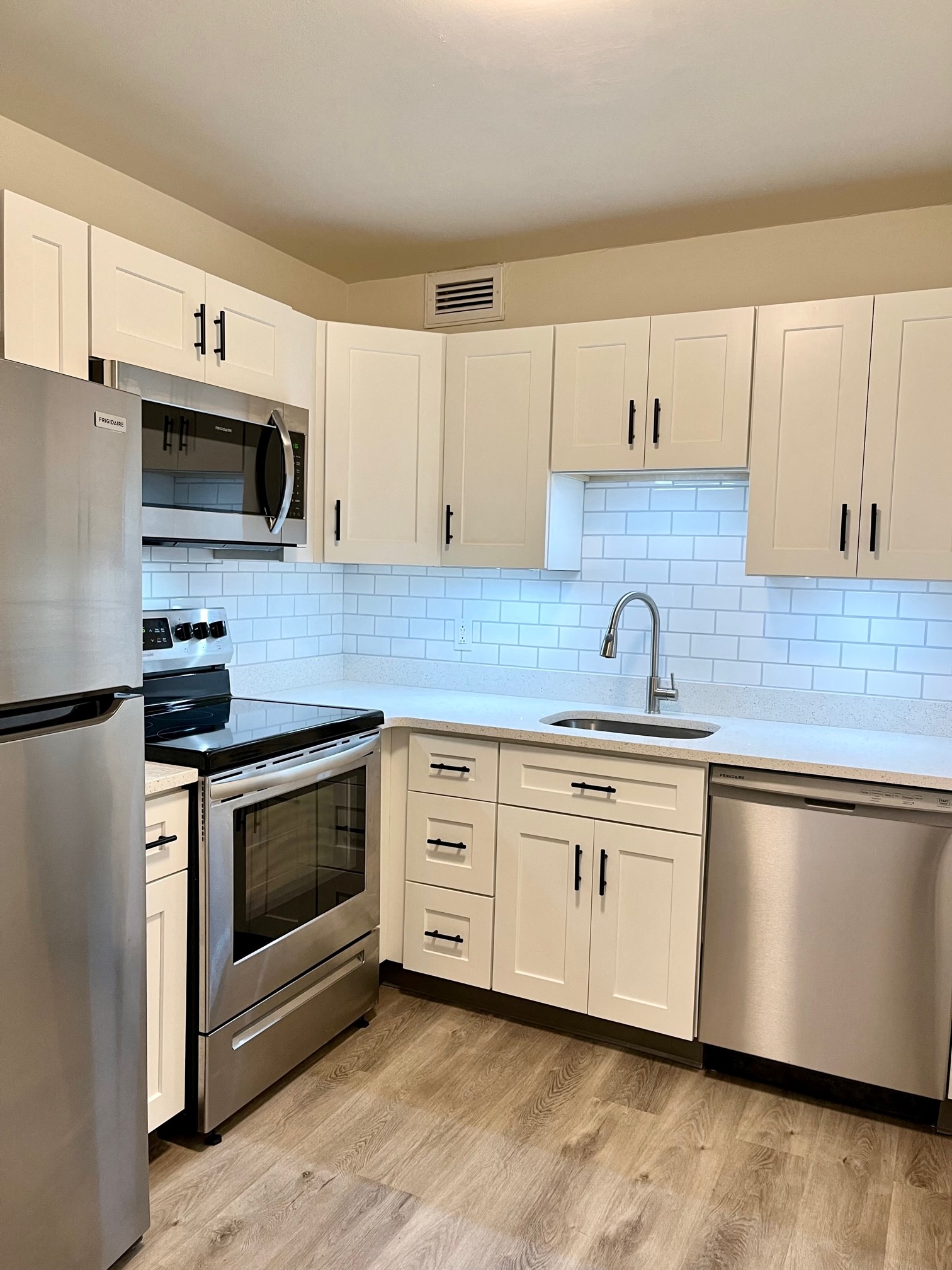 a kitchen with white cabinets and stainless steel appliances