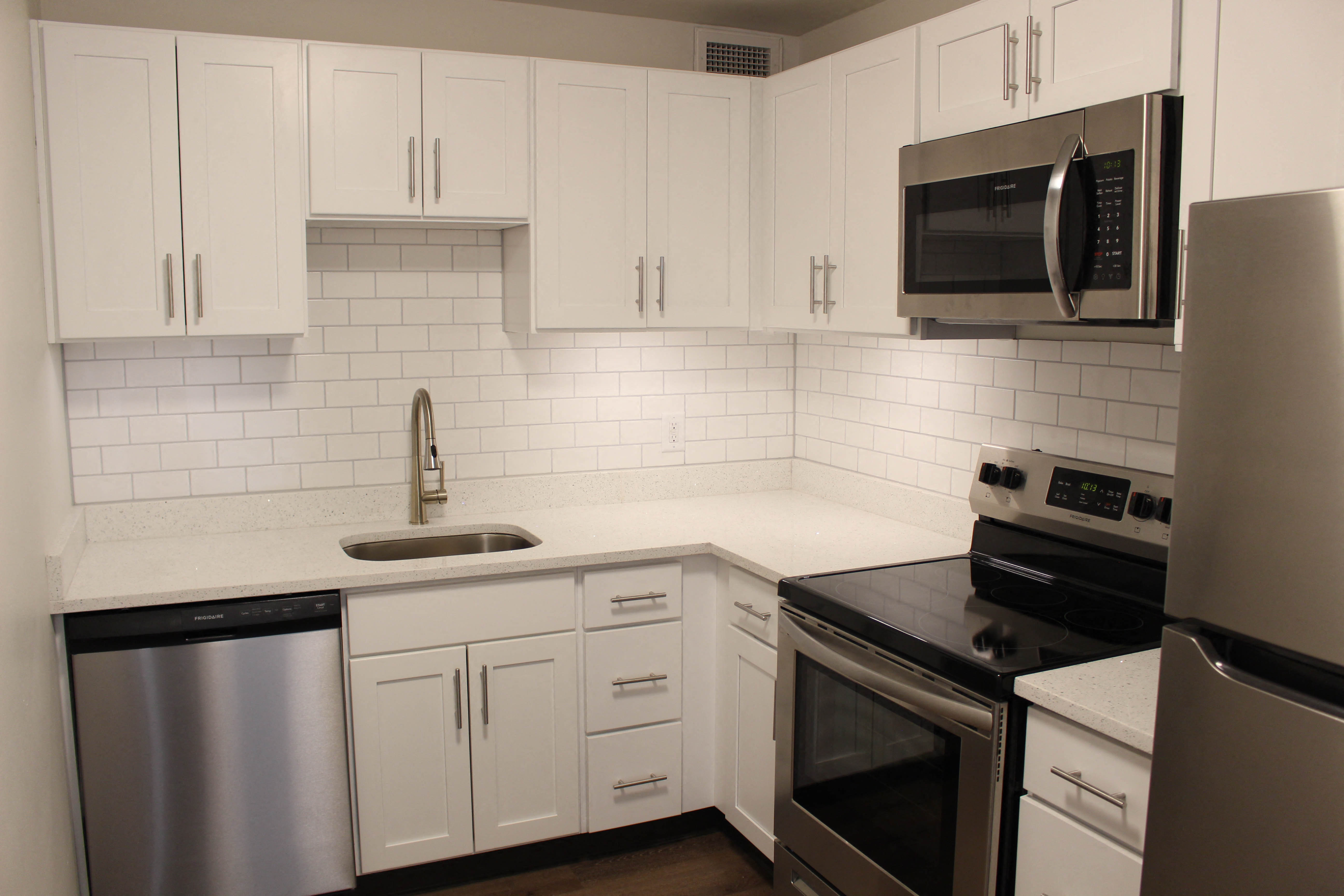 a kitchen with white cabinets and stainless steel appliances