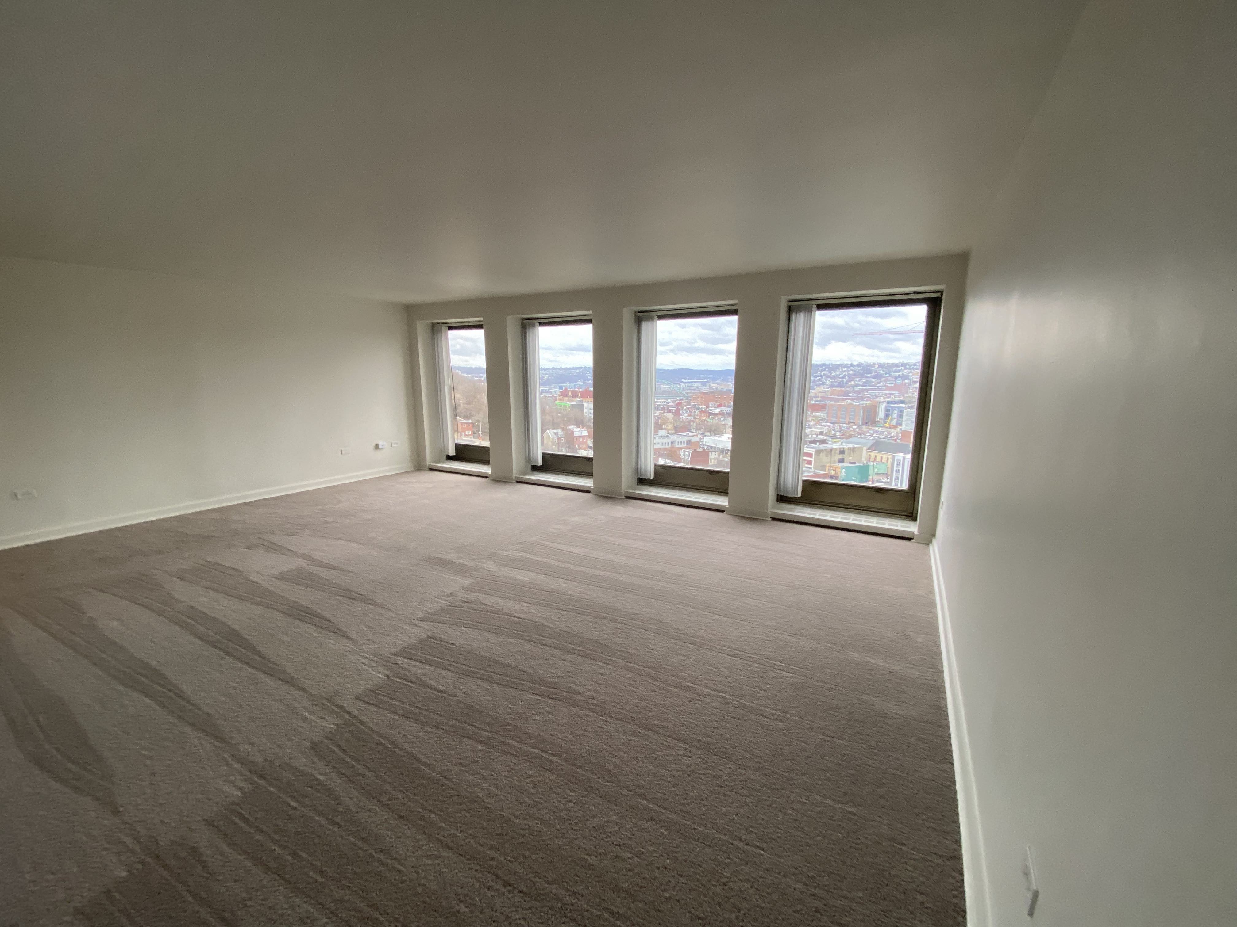 an empty living room with a view of a window