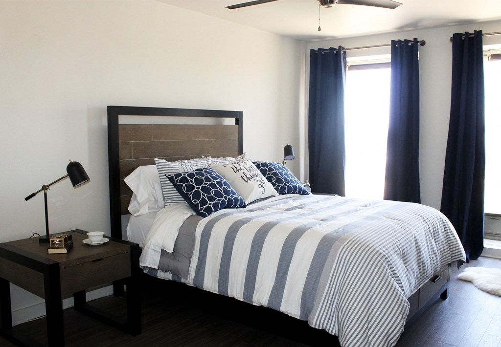 a bedroom with a bed and blue and white striped comforter and pillows