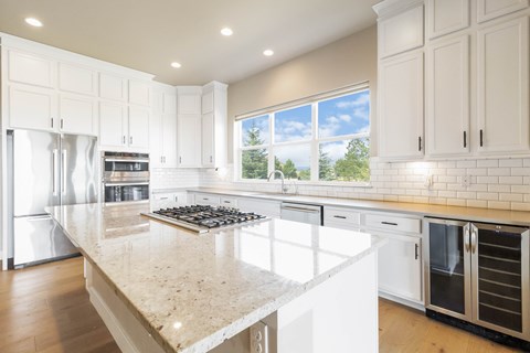 A kitchen with white cabinets and a granite countertop.