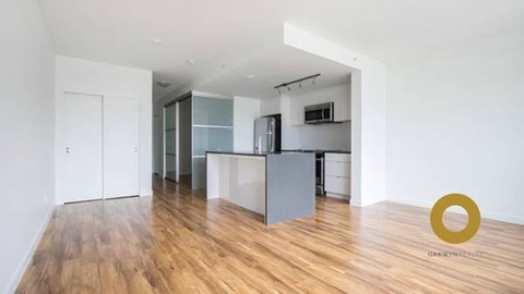 A kitchen with white cabinets and a wooden floor.