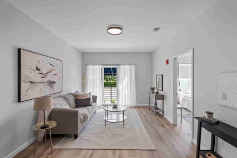 A living room with a couch, a chair, a coffee table, and a painting on the wall.