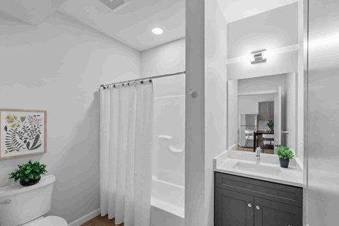 A bathroom with a white toilet, a white sink, and a white shower curtain.
