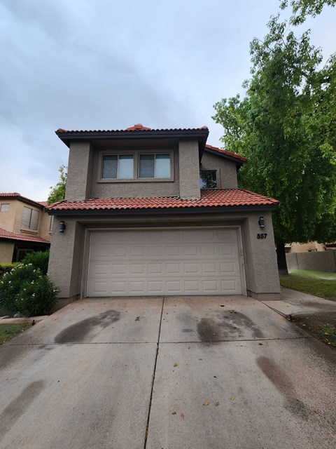 A house with a garage door and a driveway.