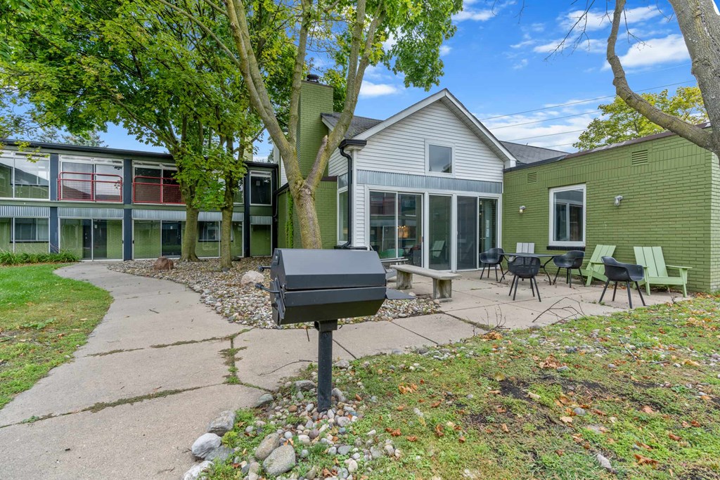 A mailbox sits on a sidewalk in front of a green building.