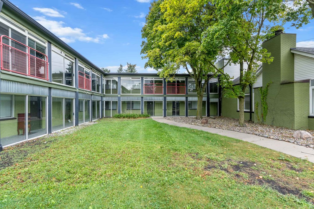 A green building with a tree in front of it.