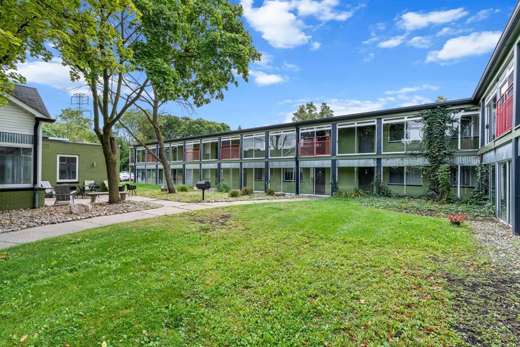 A grassy courtyard surrounded by apartment buildings.
