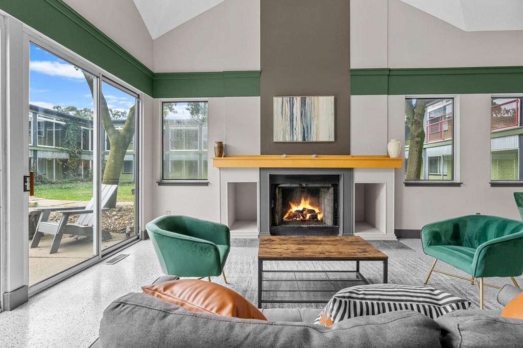A living room with a fireplace and green chairs.