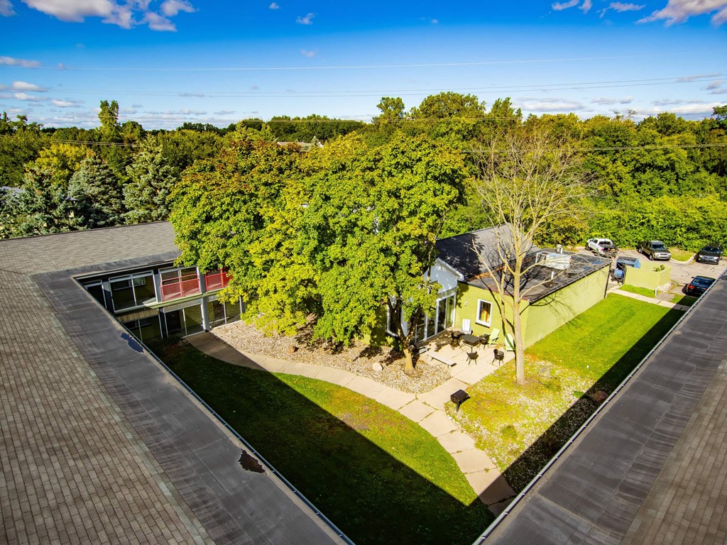 A house with a green lawn and trees in the background.
