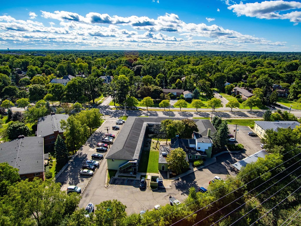 A bird's eye view of a parking lot with cars and buildings.