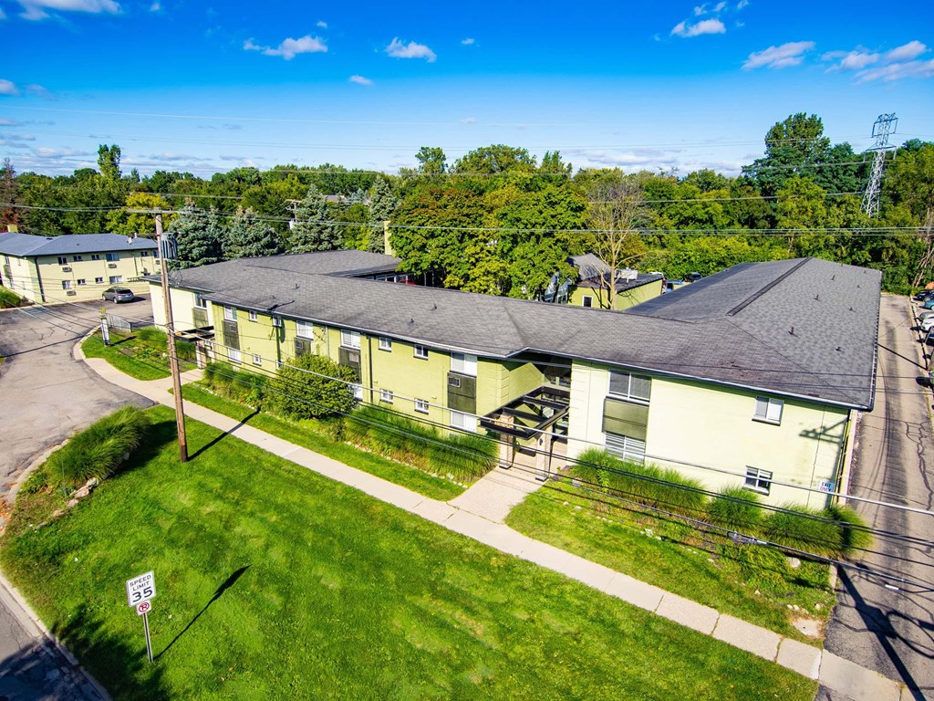Apartment complex with a green lawn and a speed limit sign of 35.