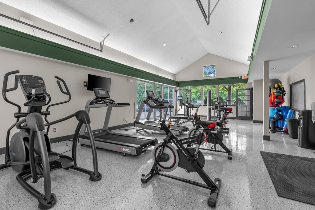 A gym with treadmills, elliptical machines, and other exercise equipment.