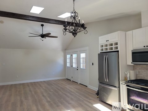 A kitchen with a stainless steel refrigerator and a ceiling fan.