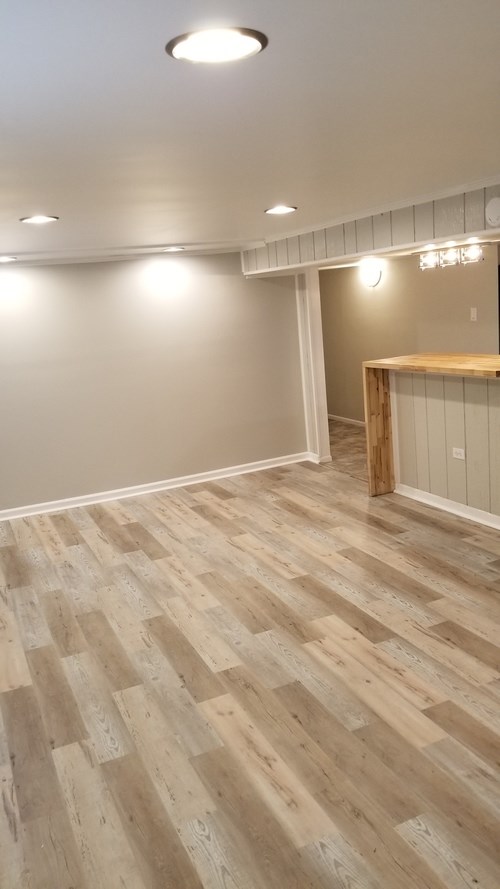 A room with wooden flooring and a white wall.