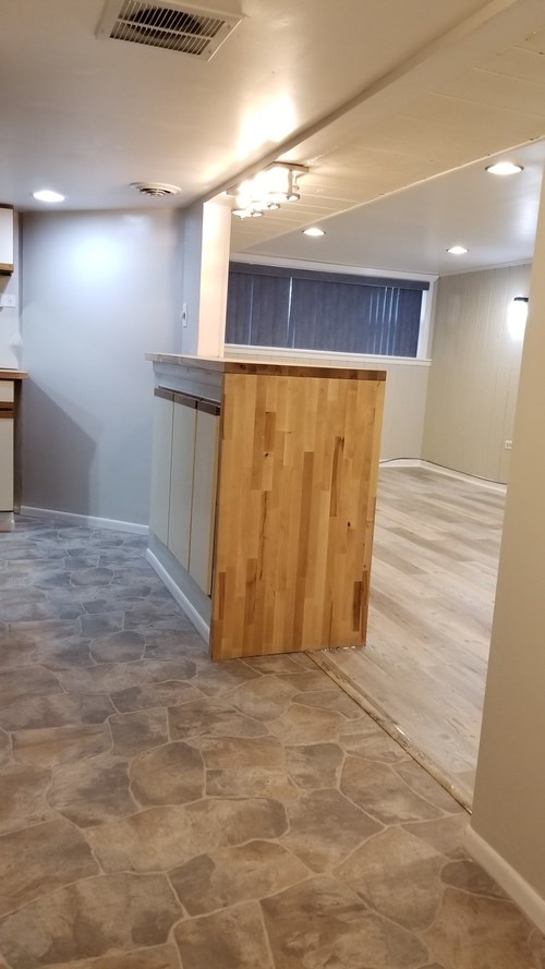 A room with a wooden counter and stone flooring.