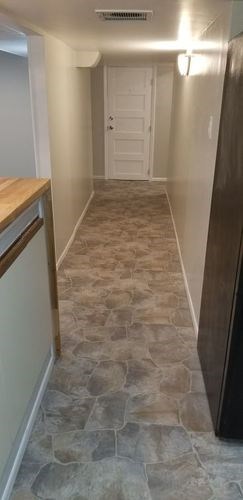 A hallway with a white door and a brown door mat.