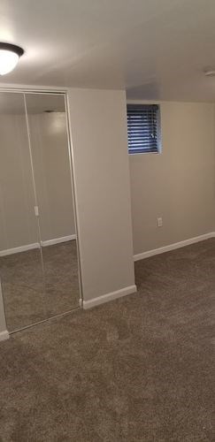 A room with a carpeted floor and a white door.
