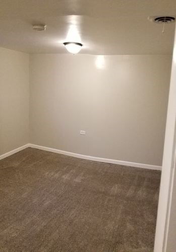 A room with a carpeted floor and a light on the ceiling.