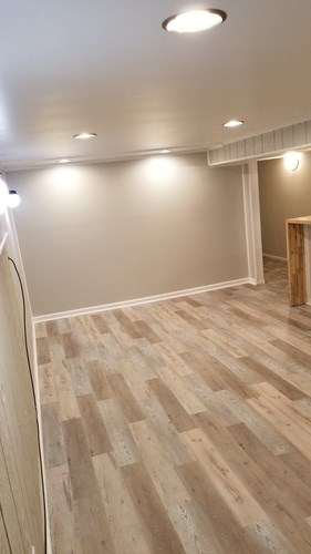 A room with wooden flooring and white walls.
