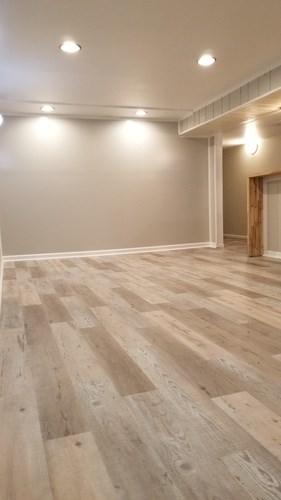 A room with wooden flooring and white walls.