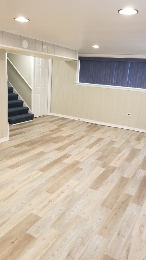 A room with wooden flooring and a staircase.