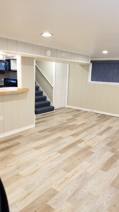 A room with wooden flooring and a staircase.