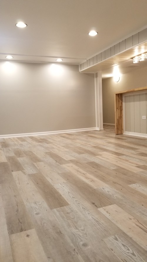 A room with wooden flooring and white walls.