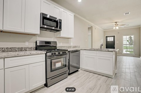 A kitchen with white cabinets and a black stove top oven.