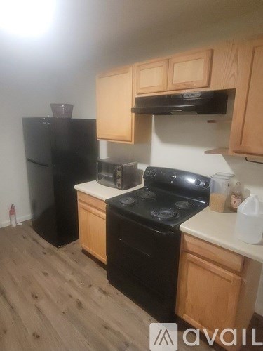 A kitchen with black appliances and wooden cabinets.
