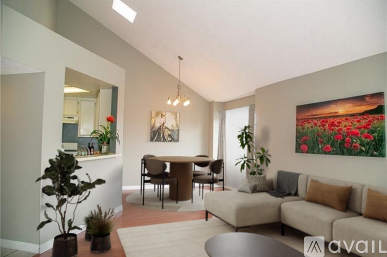 A living room with a couch, chairs, and a painting on the wall.