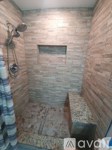 A shower area with a glass door and a shower head.
