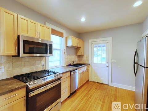 A kitchen with wooden cabinets and a black stove top oven.